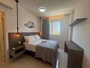 Un dormitorio pequeño con una cama y una ventana. en Apto c/ parrilla a 450 m del mar, Perequê SRF0601, en Perequê