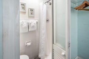 a white bathroom with a shower and a toilet at Curry House - Room 5 in Key West