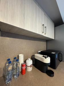 a counter with bottles of water and a coffee maker at Madona Apartment in Craiova