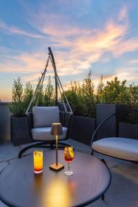 a patio with two chairs and a table with two drinks at Hotel Raffaello - Sure Hotel Collection by Best Western in Rome