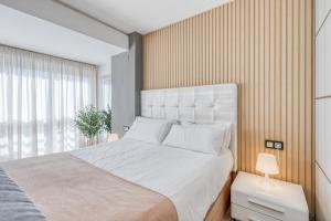 a bedroom with a large white bed and a window at Estepona Real Apartamentos in Estepona