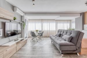 a living room with a couch and a television at Estepona Real Apartamentos in Estepona