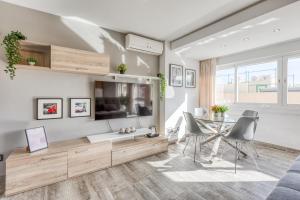 a living room with a tv and a table and chairs at Estepona Real Apartamentos in Estepona
