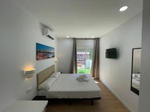 a small bedroom with a bed and a window at Lux Hostal in Hospitalet de Llobregat