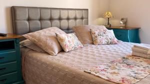 a bedroom with a bed with pillows and a desk at Hotel Vitoria Marchi in Serra Negra