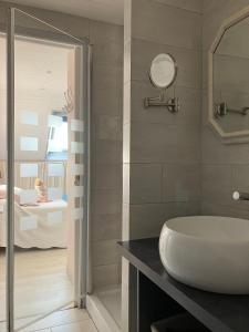 een badkamer met een wastafel, een spiegel en een bad bij Ty Annick chambres d'hôtes in Kermen