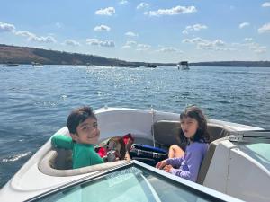 Dos niños y un perro en un bote en el agua en Flamboyant Boat, en Ubatuba 8 fotos más
