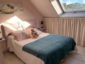 een teddybeer op een bed in een slaapkamer bij Ty Annick chambres d'hôtes in Kermen