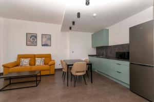 eine Küche mit einer Couch und einem Tisch in einem Zimmer in der Unterkunft Palm Suites Gran Vía in Alicante