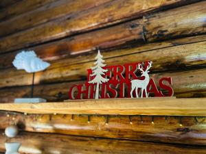 Chalet Seaview by AR Group Hotels في إزولا ديلي فيمين: علامة على جدار خشبي عليها شجرة عيد الميلاد