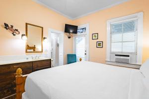 een slaapkamer met een groot wit bed en een wastafel bij Curry House Room 6 in Key West