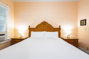 een slaapkamer met een groot bed met twee nachtkastjes bij Curry House Room 6 in Key West