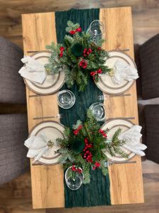 ein Tisch mit einem Weihnachtskranz und Tellern darauf in der Unterkunft Saulės Tako apartamentai in Druskininkai