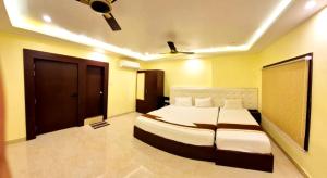 Un dormitorio con una cama y un ventilador de techo. en Hotel Royal - View - Residency & Restaurant Bodh Gaya Near Temple & The Great Buddha Statue Fully Air Conditioning Rooms- Premium Quality Hotel Inn Bodh Gaya, en Bodh Gaya