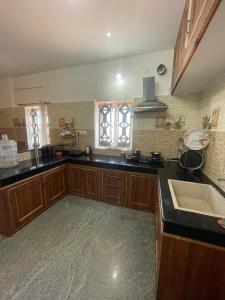 a kitchen with wooden cabinets and a sink at IndivaStays - Moon Stone Villa in Ooty