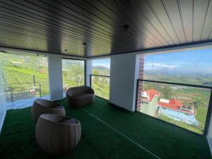 a room with a view of a house with windows at IndivaStays - Moon Stone Villa in Ooty