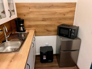 a small kitchen with a sink and a microwave at Ferienwohnung Goldener Hirsch in Schneeberg