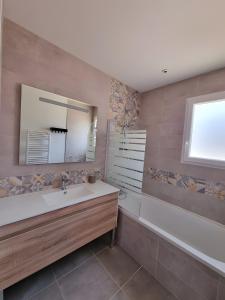 een badkamer met een wastafel en een spiegel bij Villa Hestia in Goudargues
