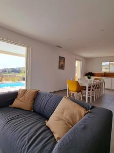 een woonkamer met een blauwe bank en een eetkamer bij Villa Hestia in Goudargues