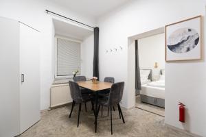 a dining room with a table and chairs and a bedroom at Quiet - 4 Guests - Self Check-in - Netflix - 35m2 in Leoben