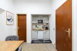 a kitchen with white cabinets and a wooden door at Quiet - 4 Guests - Self Check-in - Netflix - 35m2 in Leoben +19 photos