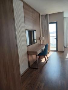 a living room with a desk and a blue chair at A La Carte Hạ Long- Little Kun Homestay in Ha Long