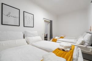 a white room with two beds and a couch at Quiet - 4 Guests - Self Check-in - Netflix - 35m2 in Leoben