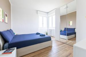 een slaapkamer met een blauw bed en een spiegel bij Milano - Open Space in Cusano Milanino