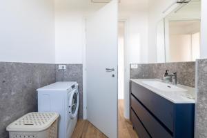 een badkamer met een wasmachine en een wastafel bij Milano - Open Space in Cusano Milanino +20 foto's