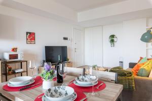een woonkamer met een eettafel met rood servies bij Milano - Open Space in Cusano Milanino