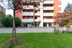 een appartementencomplex met roze bloemen ervoor bij Milano - Open Space in Cusano Milanino