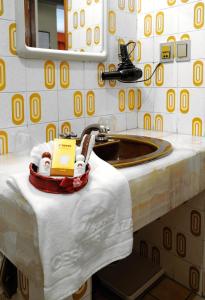 Cesar's Plaza Hotel في كوتشابامبا: حمام مع حوض وكتاب على منشفه