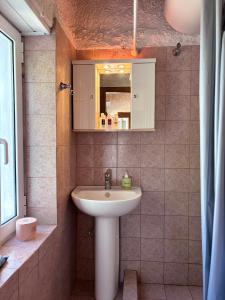 a bathroom with a sink and a mirror at Δωμάτια Εξοχή-With fireplace and view to the sea in Elíki
