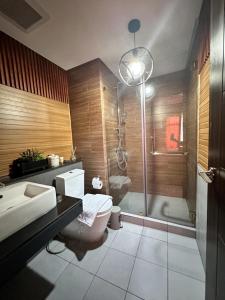 Un baño con ducha, inodoro y lavabo. en Bayfront Suite near Airport, MOA, PICC, Star City, OKADA With Fast WIFI & Netflix Free Pool Access, en Sampong