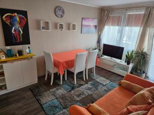 Ferienwohnung Nähe Flughafen mit Schwimmbad und Sauna في مورفلدن فالدورف: غرفة معيشة مع طاولة وكراسي وأريكة