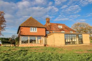 ein altes Haus auf einem Grasfeld in der Unterkunft Farm house in Newick