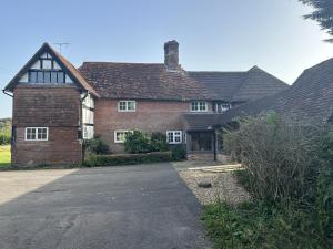 a brick house with a driveway in front of it at Great Noven Farm in Lewes