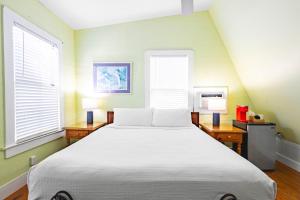 a bedroom with a large bed and two windows at Curry House - Pool, King Bed & Balcony! Room 7 in Key West