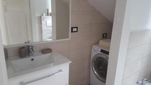 een badkamer met wastafel en wasmachine bij Mansardina in Sanremo