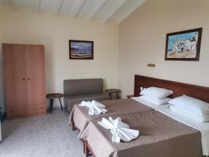 a bedroom with two beds with white towels on them at elenis village in Achladies