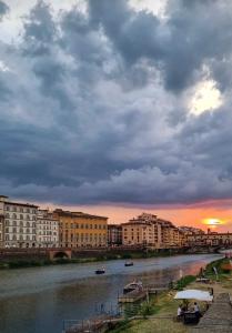 une vue sur une rivière avec des bâtiments et un coucher de soleil dans l'établissement Ama Esclusive Spa Florence, à Florence 21 autres photos
