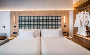 a bedroom with a large white bed with two pillows at Barcelo Valladolid in Valladolid