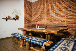 a wooden table with benches and a brick wall at Zafir House Harghita Bai Ski in Harghita-Băi +20 photos