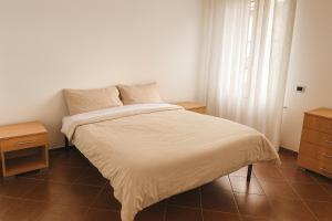a bedroom with a white bed with two night stands at Palazzo Gregorio in Parma