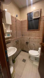 a bathroom with a toilet and a tv on the wall at فندق اجنحة السمو إن in Aḩad al Masāriḩah