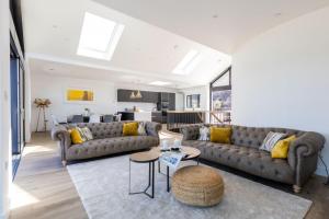 een woonkamer met twee banken en een keuken bij Ocean Skies in Porthtowan