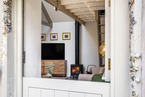 a living room with a fireplace and a tv at Birch Studio in Camborne