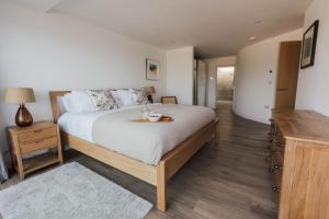 een slaapkamer met een groot bed en een tafel. bij Ocean Skies in Porthtowan