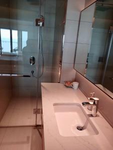 a bathroom with a sink and a shower at Little Kun - A La Carte Hạ Long Homestay view Biển in Ha Long