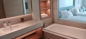 a bathroom with a sink and a large mirror at Little Kun - A La Carte Hạ Long Homestay view Biển in Ha Long